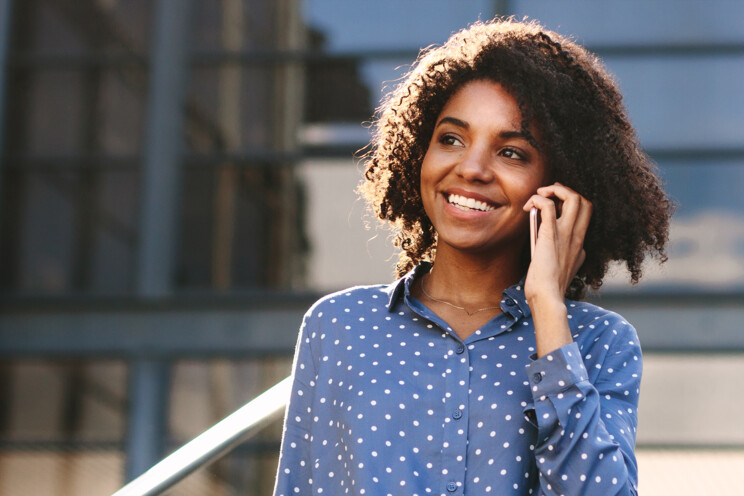 Close up of woman on the phone leaving an office