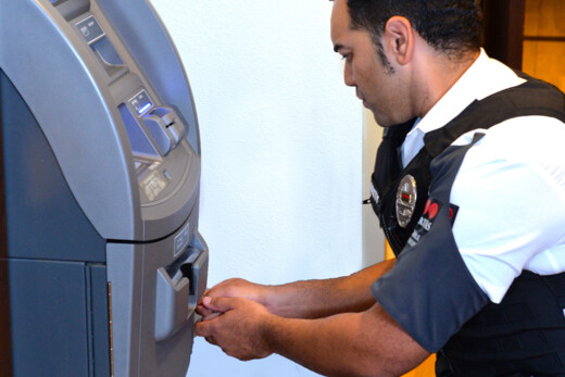 Vigilante de Securitas dando servicio a un cajero automático en sucursal bancaria