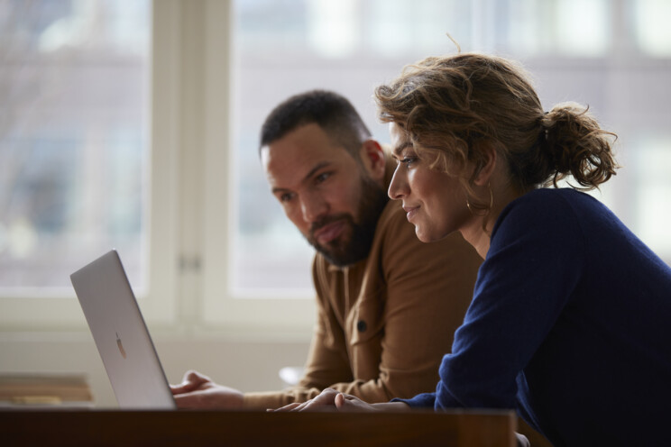 Man och kvinna tittar på laptop