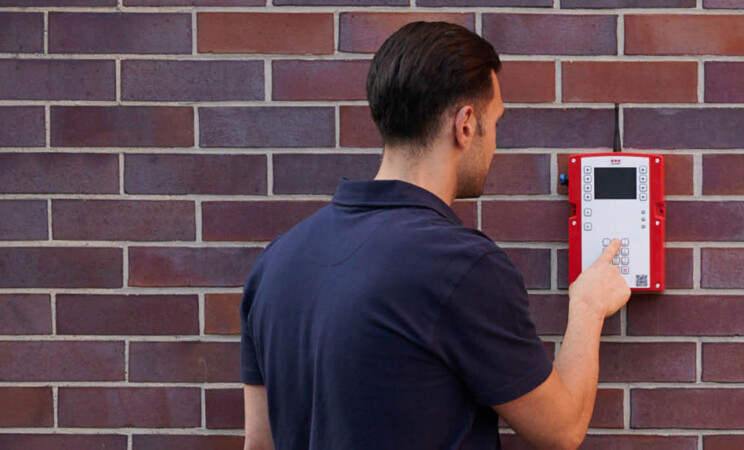 Ein Mitarbeiter bedient eine mobile Brandmeldeanlage