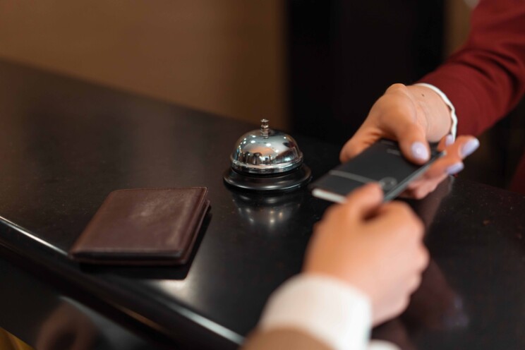Hotelmedarbejder rækker nøglekort til kunde