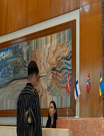Two security officers standing at an information desk inside a public indoor space.