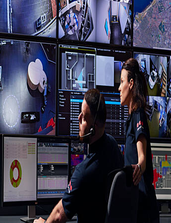 Four Securitas operators monitor cameras and events on screens in the operations center. 