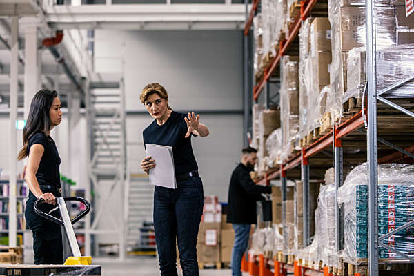 Kvinnelige lagerarbeidere som driver logistikk i et begrenset område som er beskyttet av et adgangskontrollsystem.