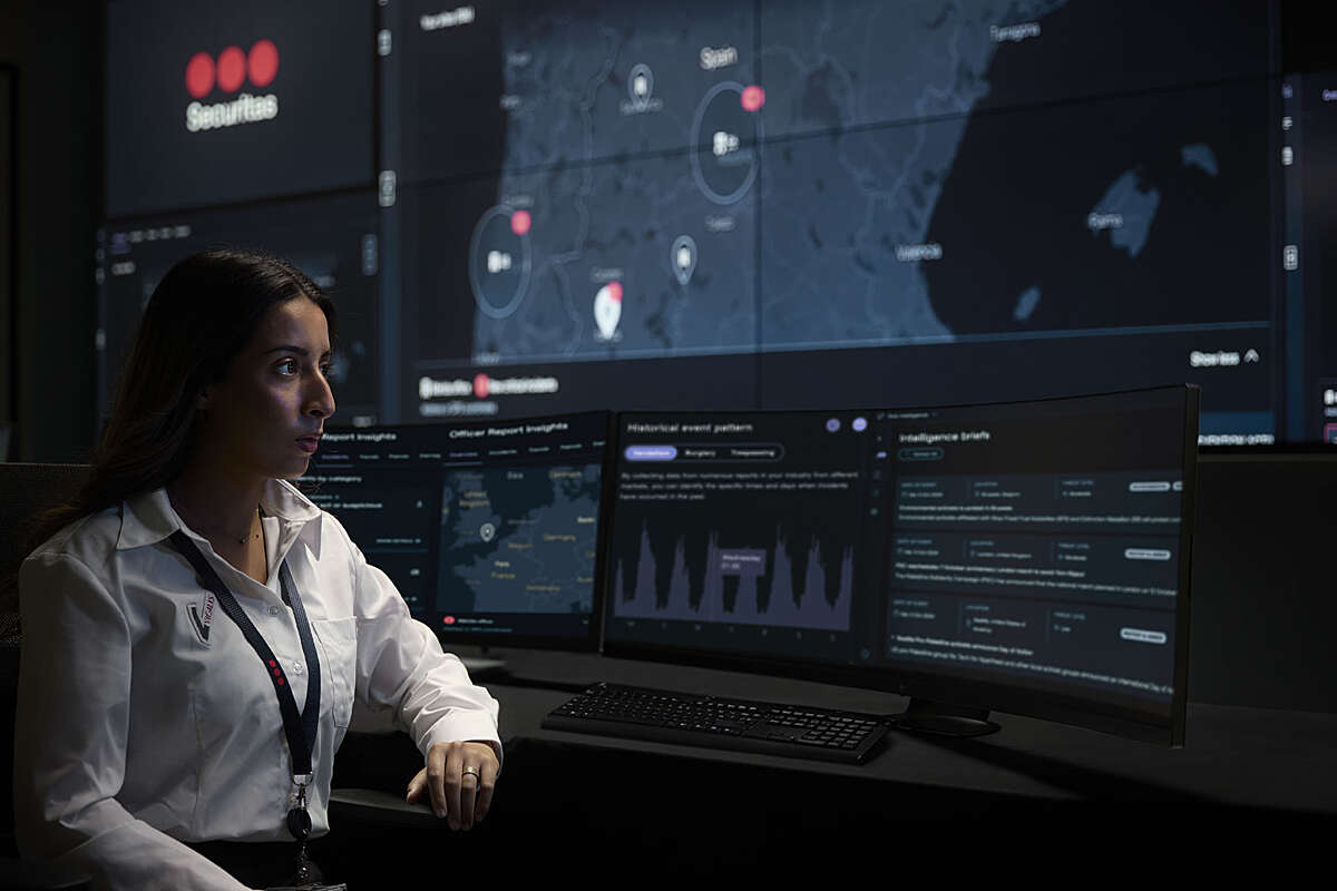 Securitas operatior mirando en la pantalla con señales de alarma en el centro de operaciones de seguridad