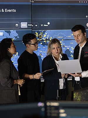 Four Securitas analysts looking at information, surrounded by large screens.