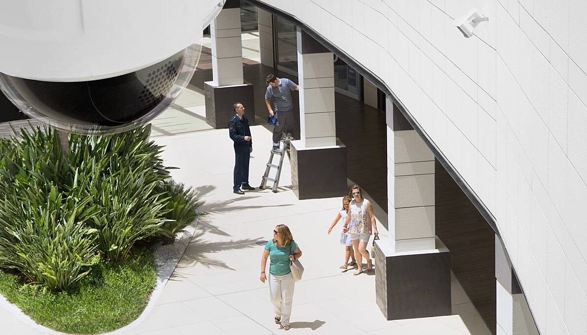 A cctv camera monitoring people passing by