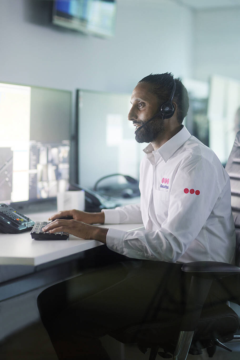 Smiling Securitas officer infront of mobile patrole securitas car