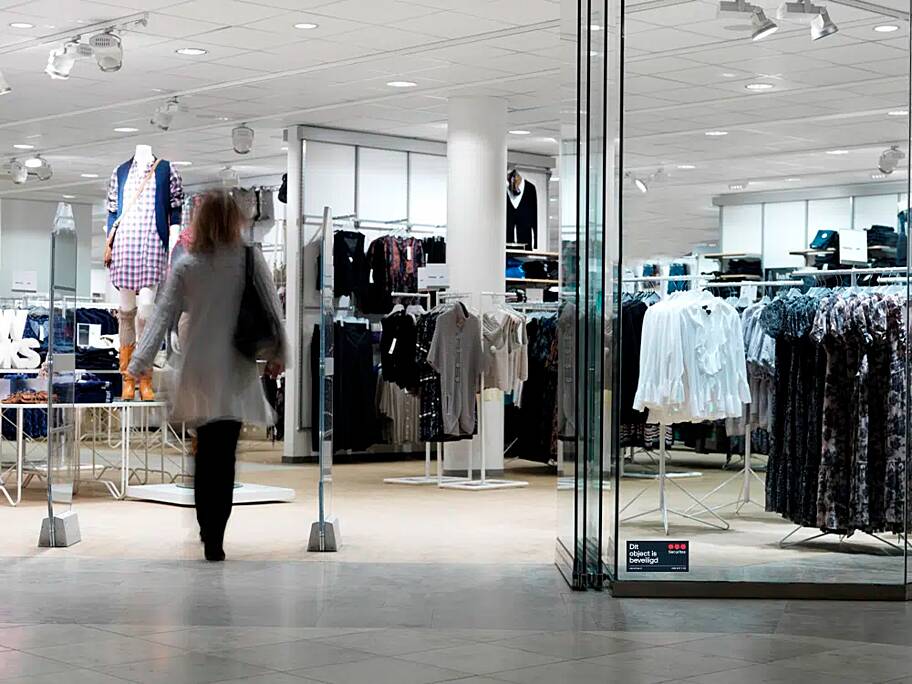 Entree van een kledingwinkel met detectiepoortjes en zichtbare beveiligingsmaatregelen.