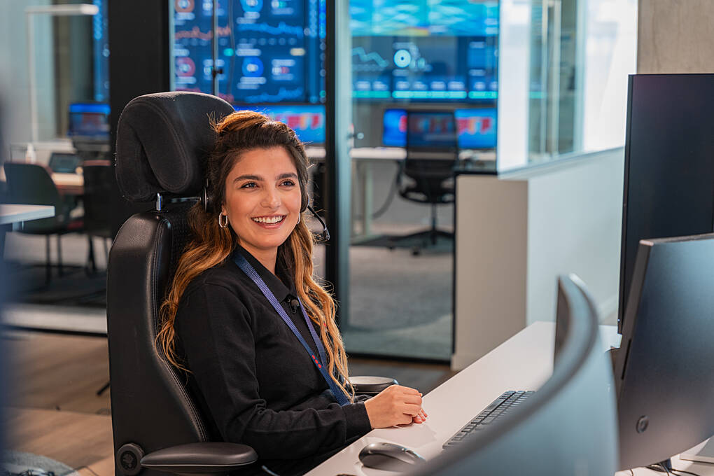 Female SOC operator monitoring alarm systems.