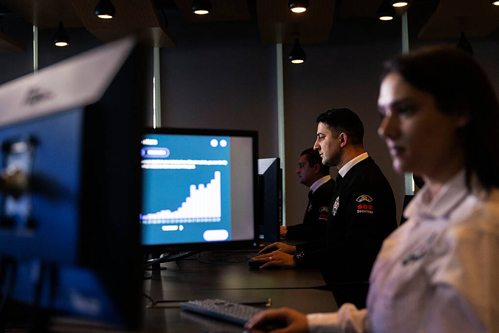 Security professionals monitoring operational data and risk indicators through digital dashboards in a security operations environment.