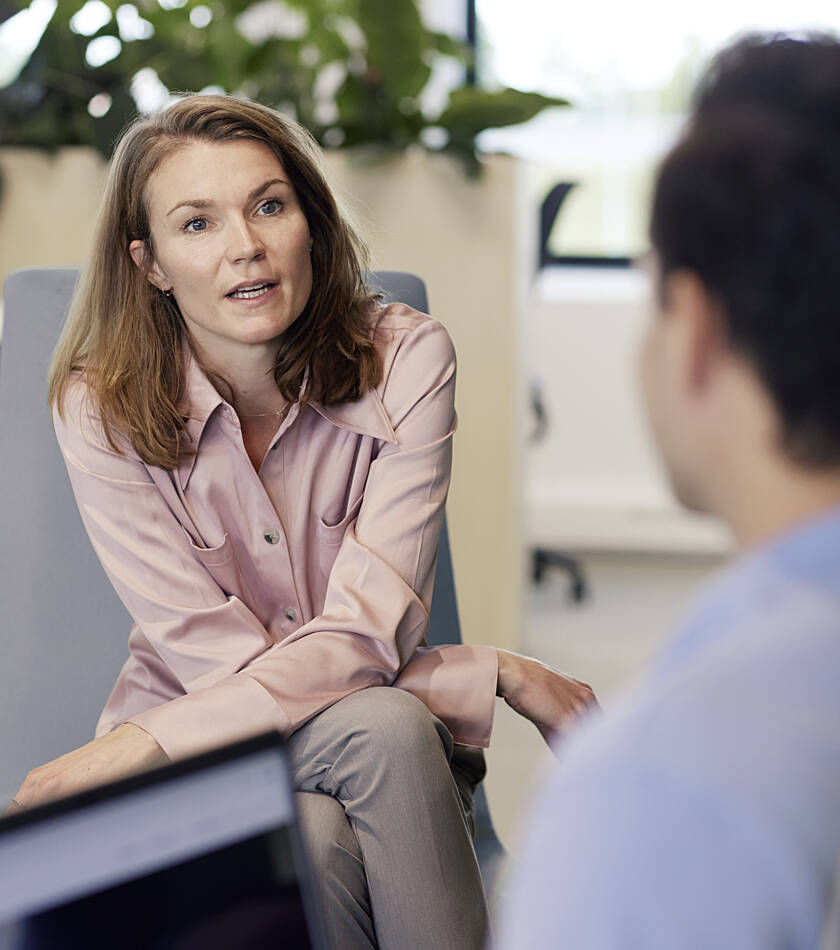 Two employees discussing professional development and career opportunities in an office environment.