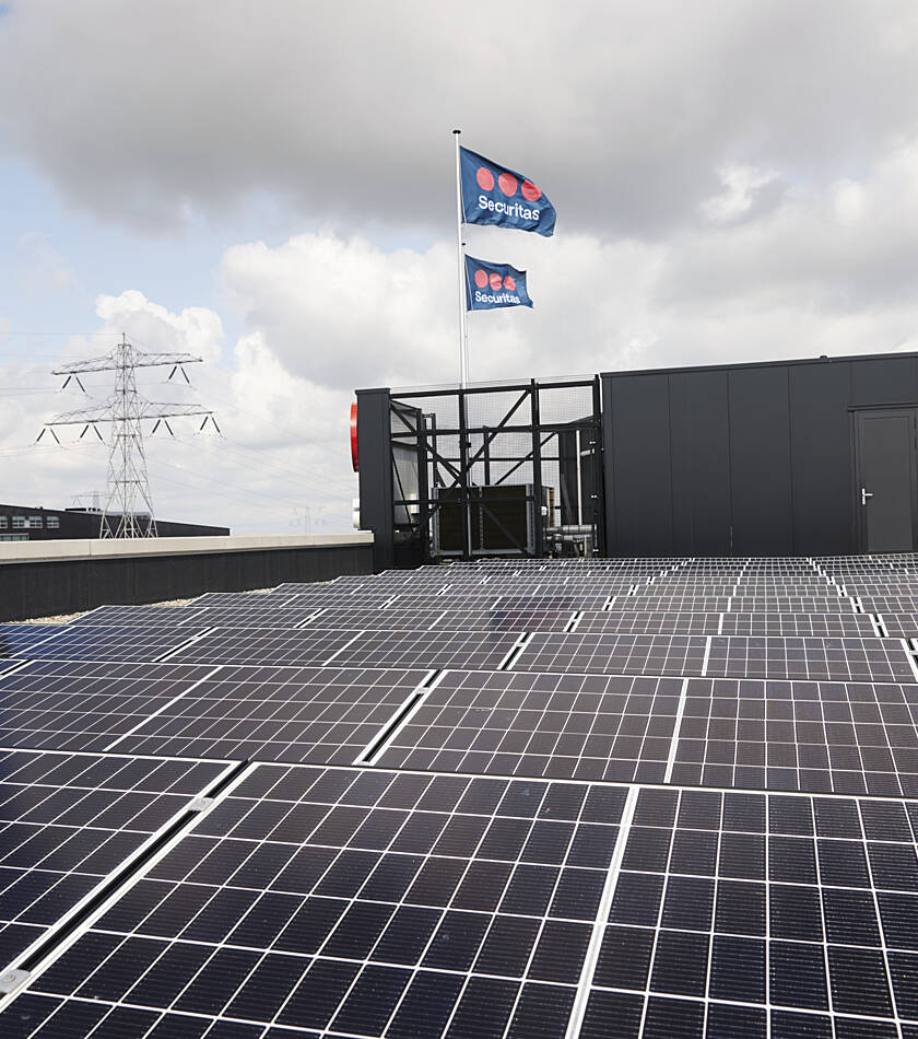 Guard patrolling a solar-paneled building roof