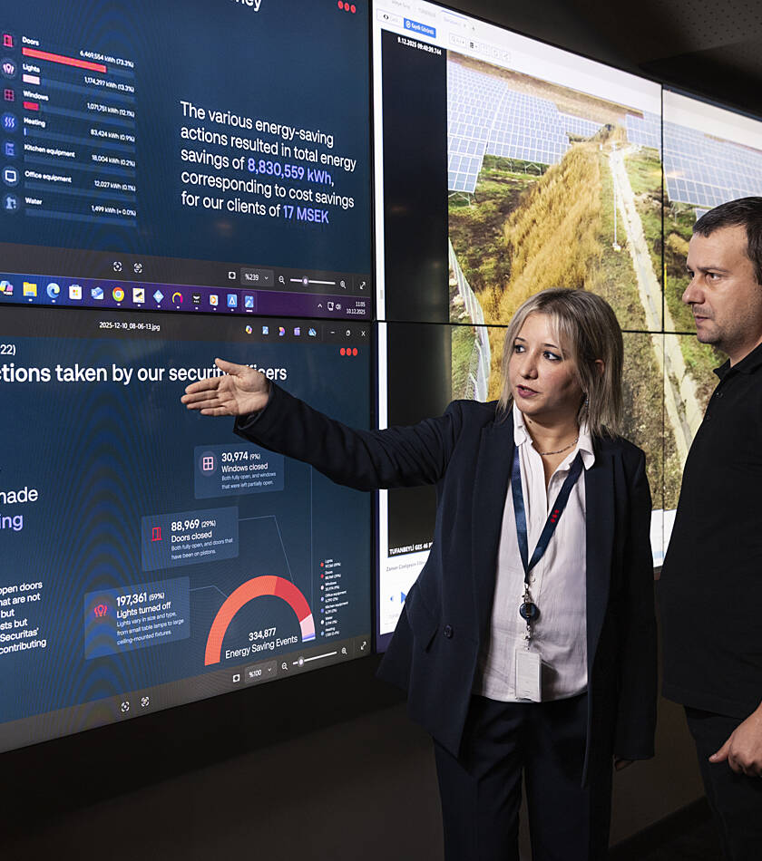 Two Securitas employees discussing the company’s energy-saving strategy in a professional setting.