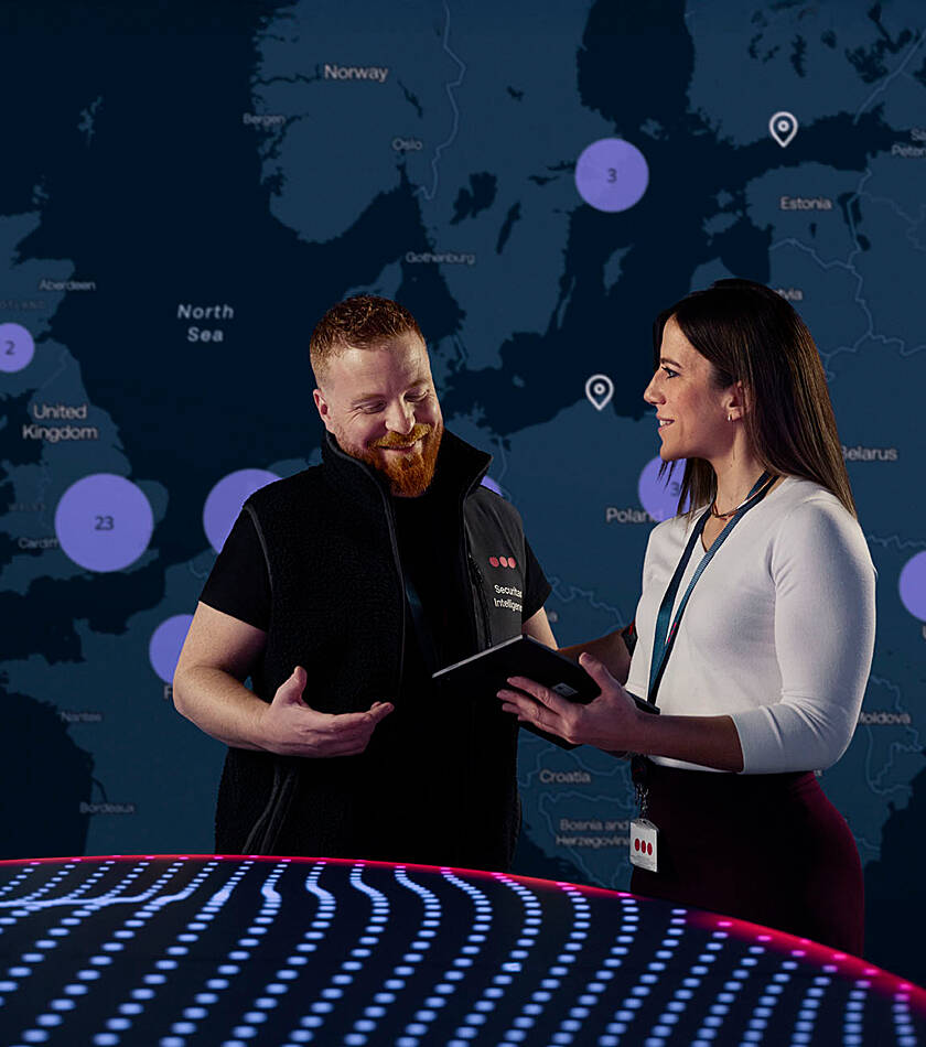Securitas Personnel standing in front of the Map that shows all alerts globally