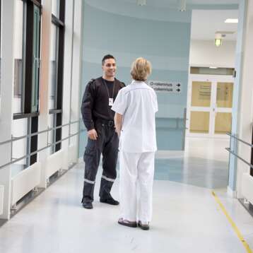 Male guard and female nurse talking in hallway