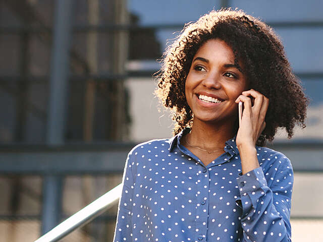 Close up of woman on the phone leaving an office.
