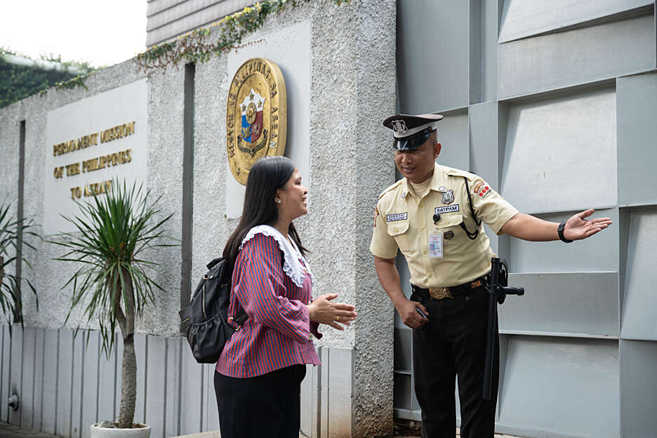 Female Securitas receptionist assists a male visitor in an office building. 