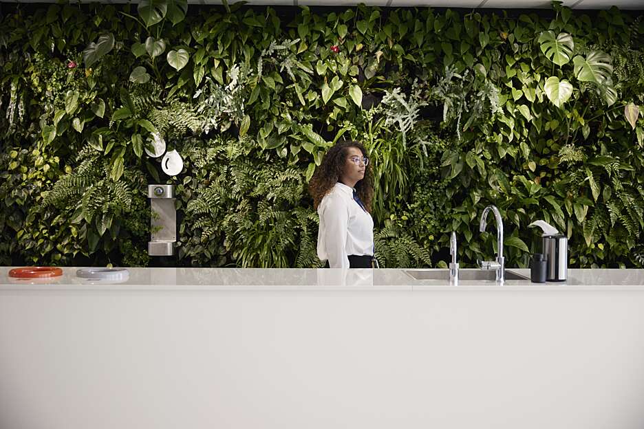 Securitas employee walks in the office with live green plants