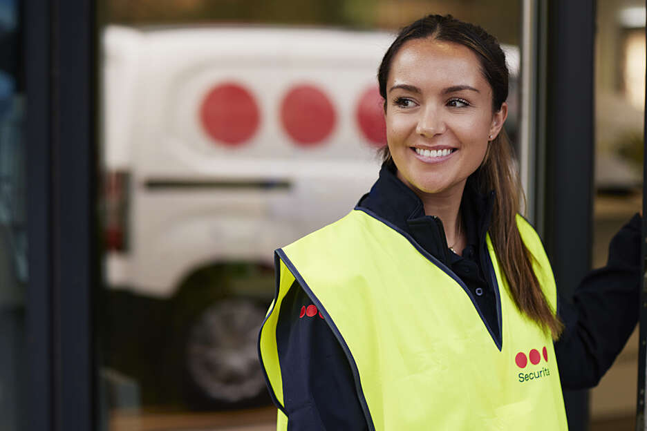 Securitas guard in a yellow west smiling