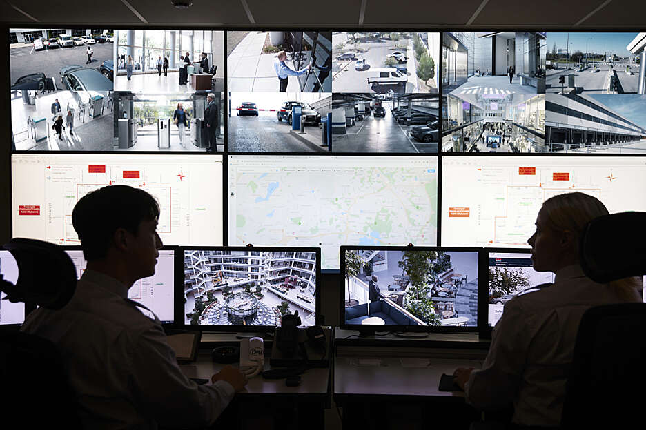 Notrufzentrale Securitas Mitarbeiter vor Bildschirmen