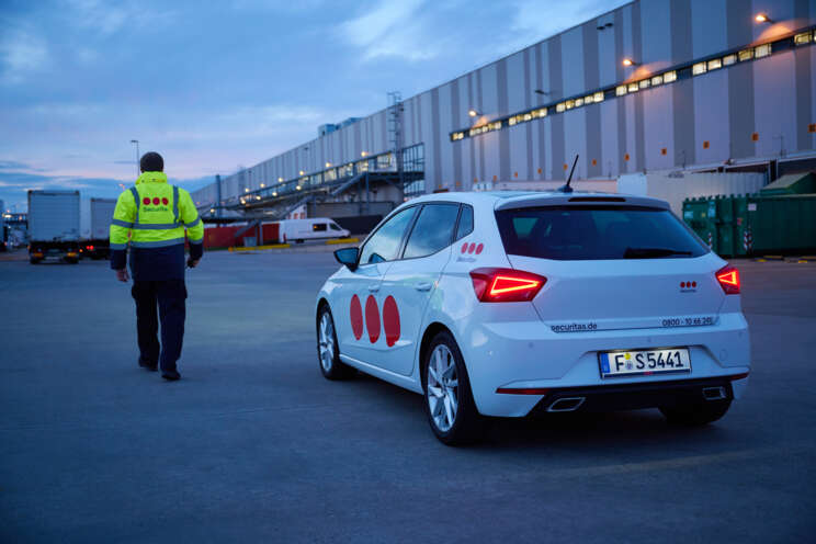Securitasov zaštitar pored službenog vozila u obilasku logističkog centra