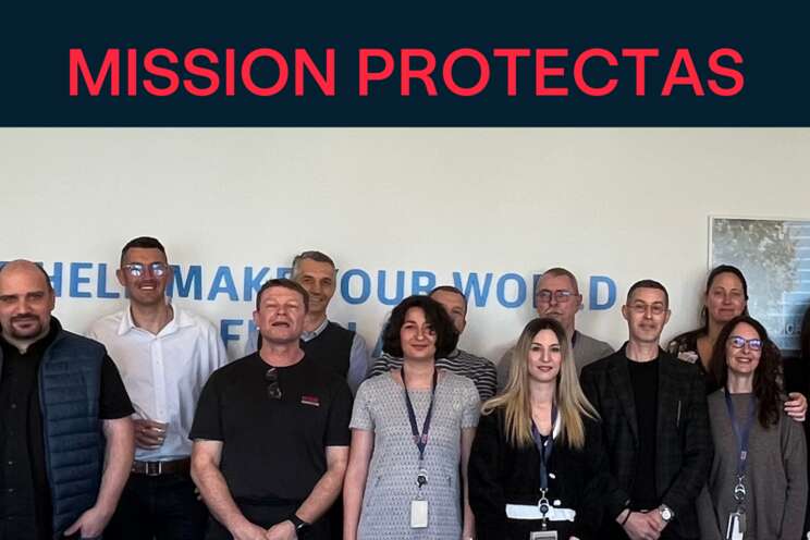 Protectas employees of all functions, ages and genders standing in front of the purpose wall in lausanne