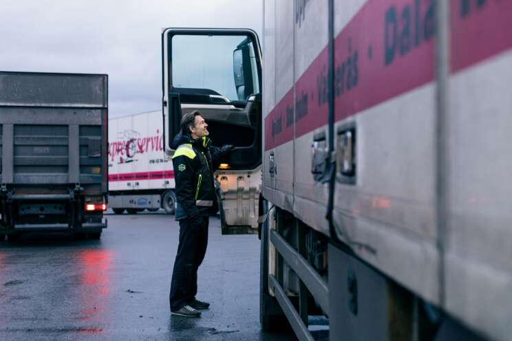 Transportmedarbetare står bredvid en lastbil