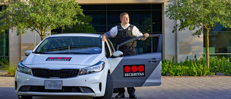 Mobile security officer standing by his car.