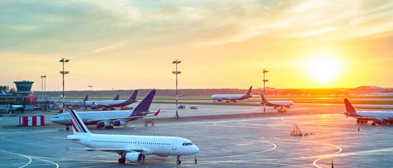 Solnedgång över landningsbana med flygplan