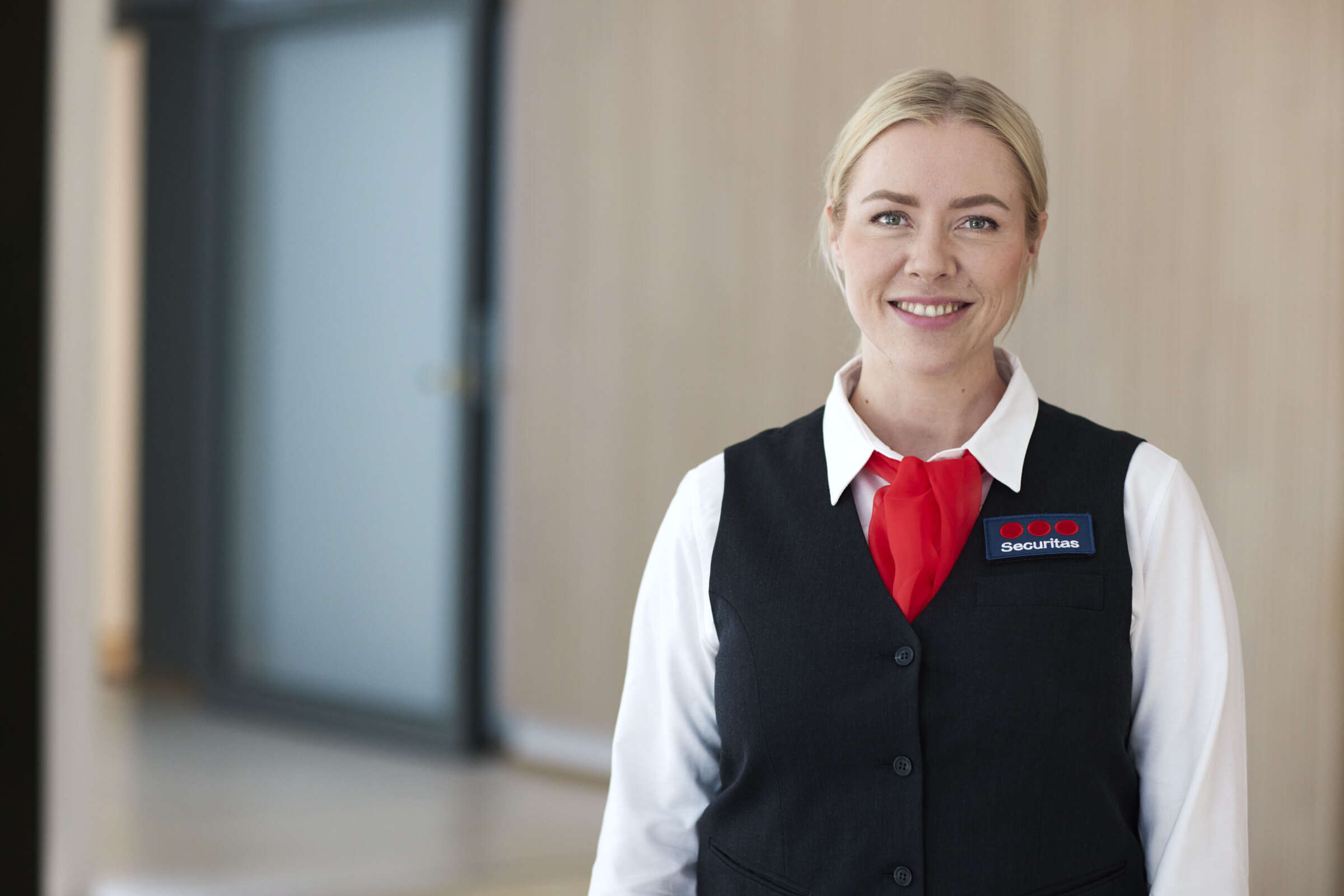 Pracownik Securitas kobieta stojąca w mundurze przed obiektem